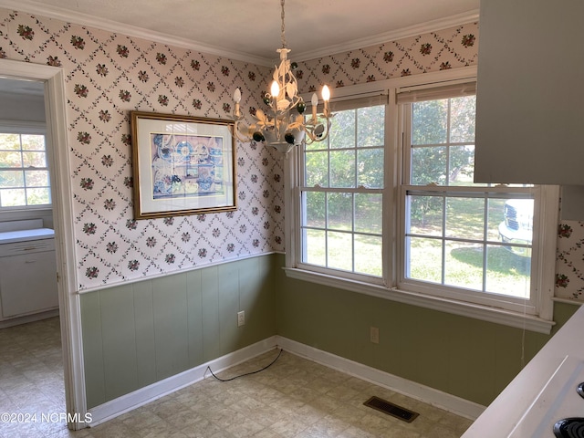 unfurnished dining area featuring crown molding, plenty of natural light, and a notable chandelier