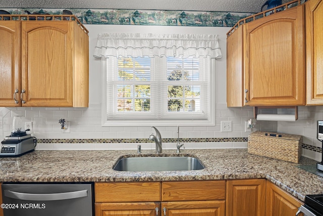 kitchen featuring dishwasher, decorative backsplash, light stone counters, and sink