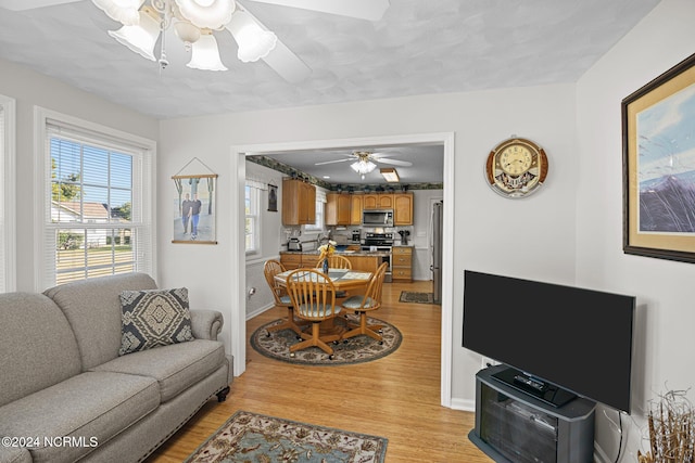 living room with ceiling fan and light hardwood / wood-style flooring