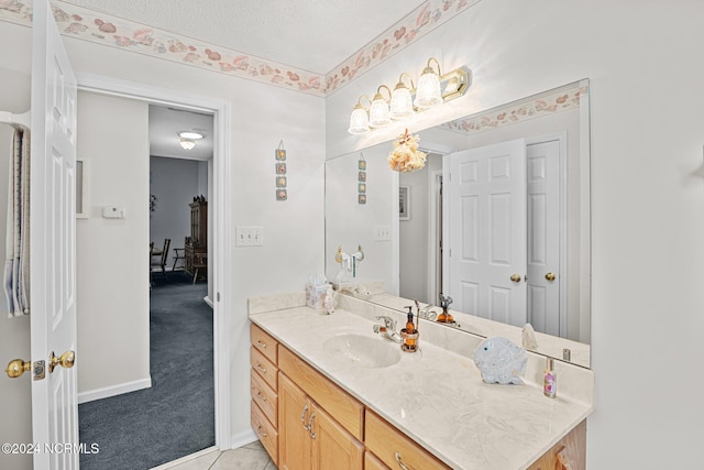 bathroom featuring tile patterned flooring, vanity, and a textured ceiling