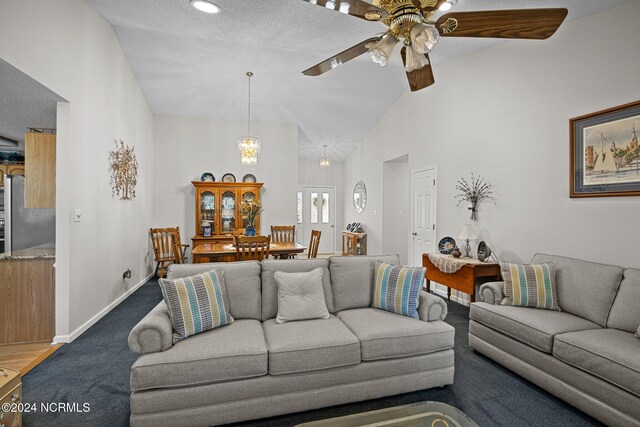 carpeted living room featuring ceiling fan, high vaulted ceiling, and a textured ceiling