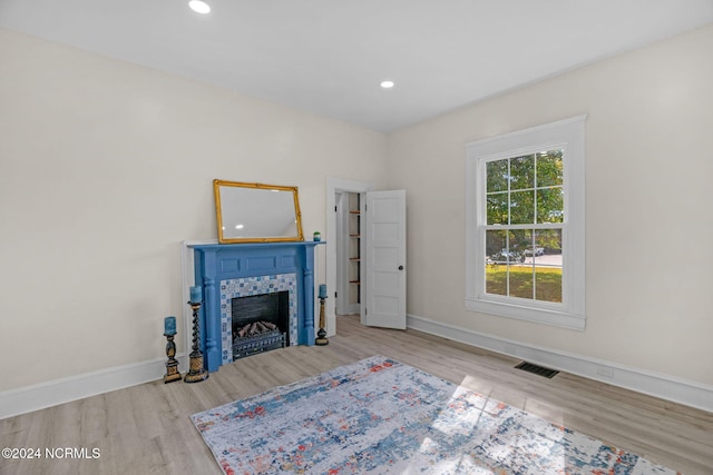interior space featuring light hardwood / wood-style flooring and a tiled fireplace