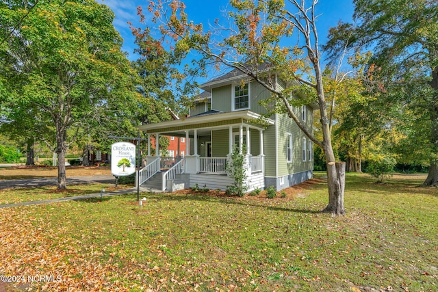 view of front of home with covered porch and a front yard