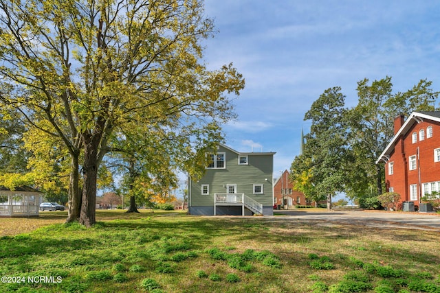exterior space featuring central AC and a yard