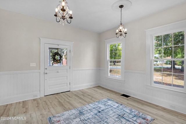 foyer entrance with a chandelier and light hardwood / wood-style floors