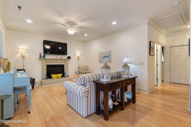 living room featuring ceiling fan, ornamental molding, and hardwood / wood-style floors