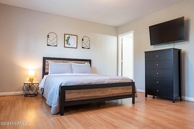 bedroom featuring light wood-style flooring and baseboards