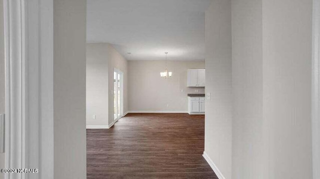 hall featuring dark hardwood / wood-style flooring and a chandelier