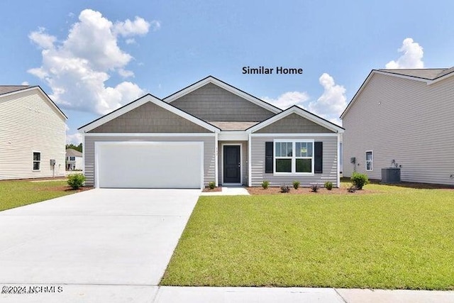 view of front of house featuring central AC, a garage, and a front yard