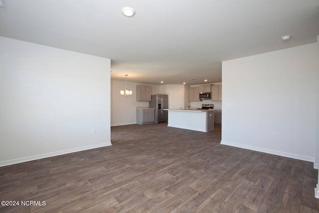 unfurnished living room featuring dark wood-type flooring and a chandelier