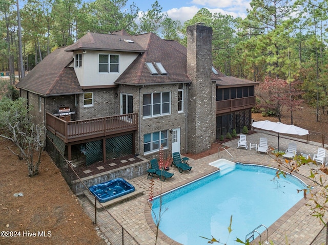 back of property with a pool with hot tub