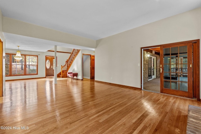 spare room with light hardwood / wood-style flooring and an inviting chandelier