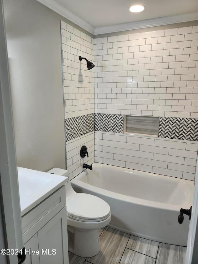 full bathroom with vanity, tiled shower / bath, toilet, and crown molding