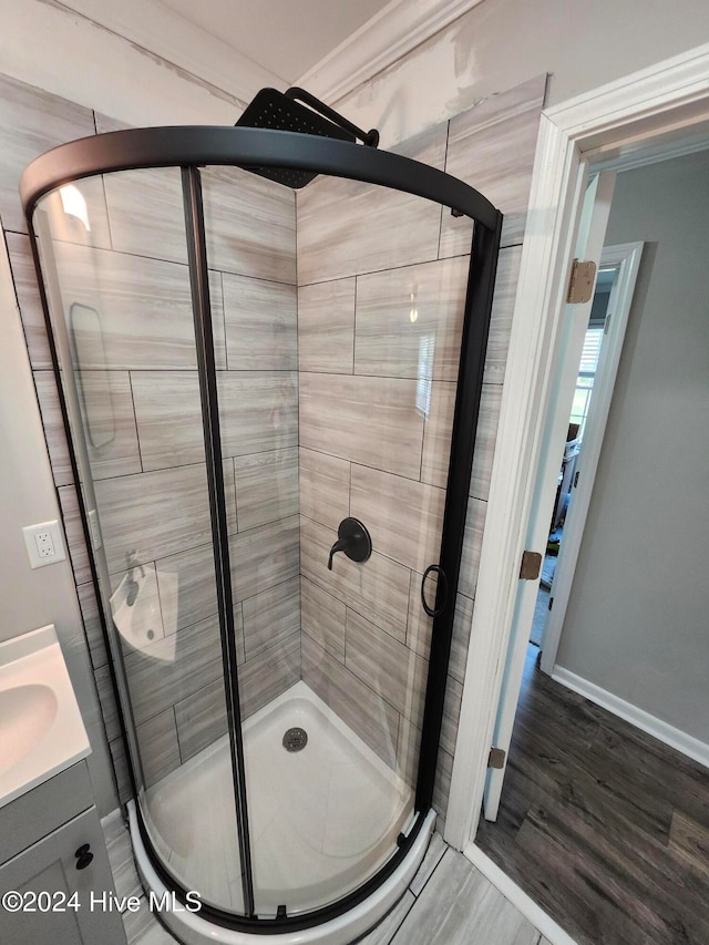 bathroom featuring vanity, an enclosed shower, and hardwood / wood-style flooring