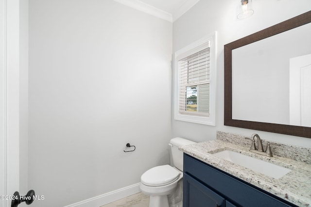 bathroom with toilet, vanity, and crown molding