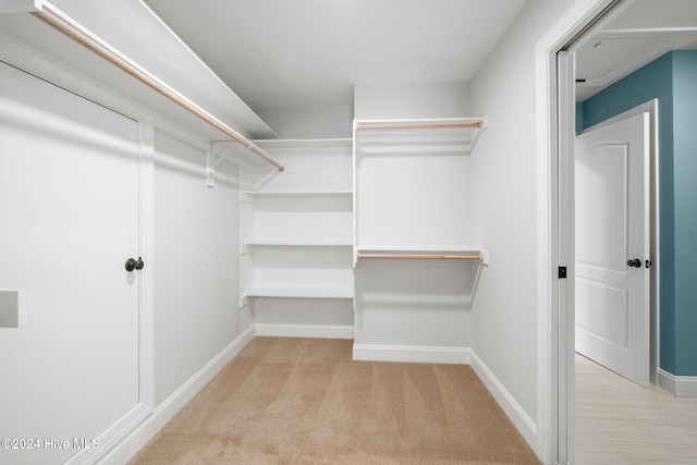 walk in closet with light colored carpet