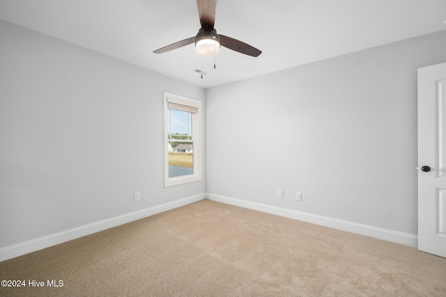 carpeted spare room featuring ceiling fan