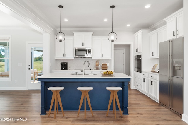 kitchen featuring white cabinetry, appliances with stainless steel finishes, sink, and a center island with sink