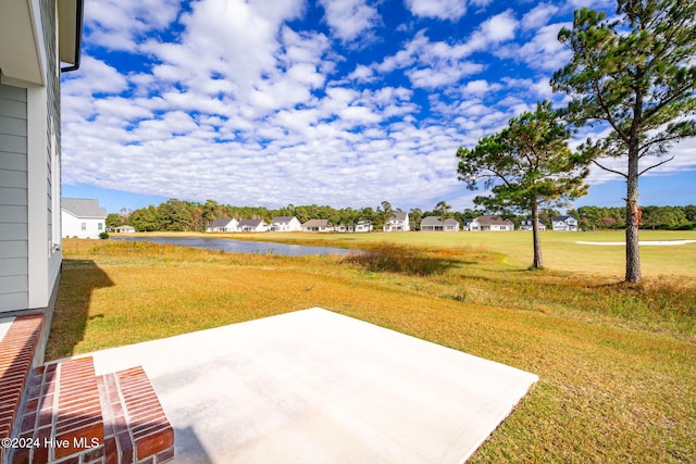 view of yard featuring a water view and a patio