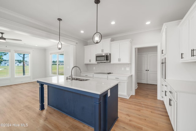 kitchen with light hardwood / wood-style floors, white cabinetry, sink, a kitchen breakfast bar, and decorative light fixtures