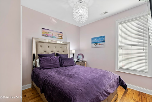 bedroom with a chandelier and hardwood / wood-style flooring