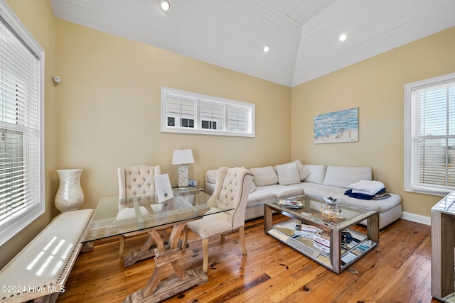 living room with vaulted ceiling, hardwood / wood-style flooring, and a healthy amount of sunlight