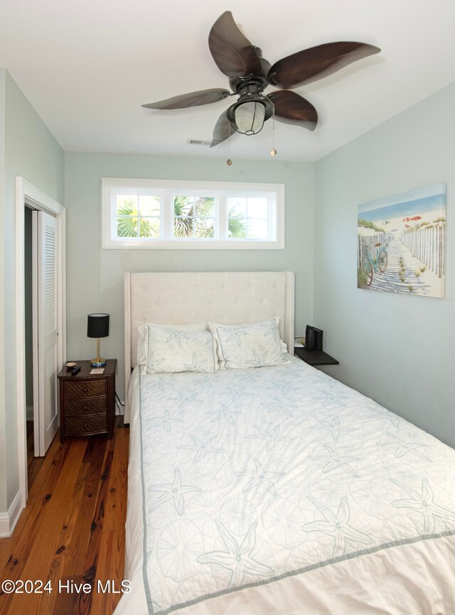 bedroom with ceiling fan, multiple windows, and dark hardwood / wood-style floors