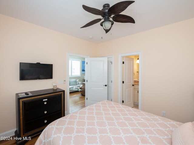 bedroom with ensuite bath, wood-type flooring, and ceiling fan