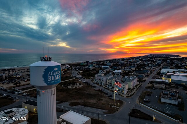 aerial view at dusk featuring a water view