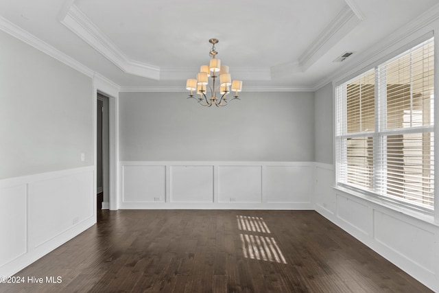 spare room featuring ornamental molding, a tray ceiling, dark hardwood / wood-style flooring, and an inviting chandelier