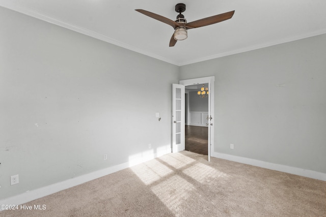 carpeted spare room featuring ceiling fan and ornamental molding