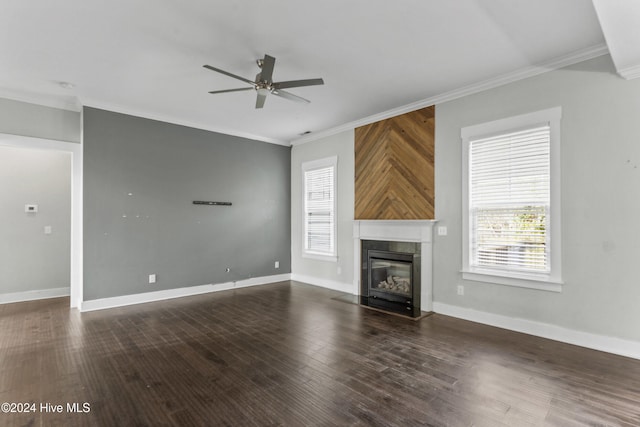 unfurnished living room with ornamental molding, ceiling fan, and dark wood-type flooring