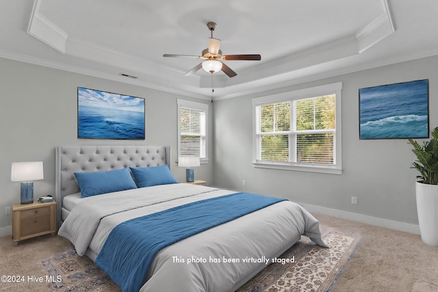 bedroom with a raised ceiling, ceiling fan, carpet, and ornamental molding