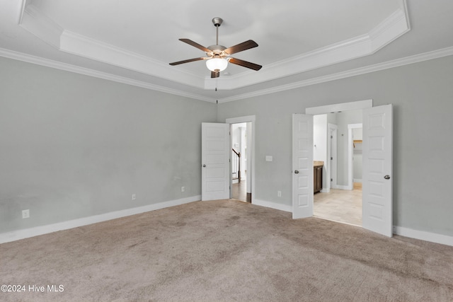 unfurnished bedroom with a raised ceiling, ceiling fan, and ornamental molding