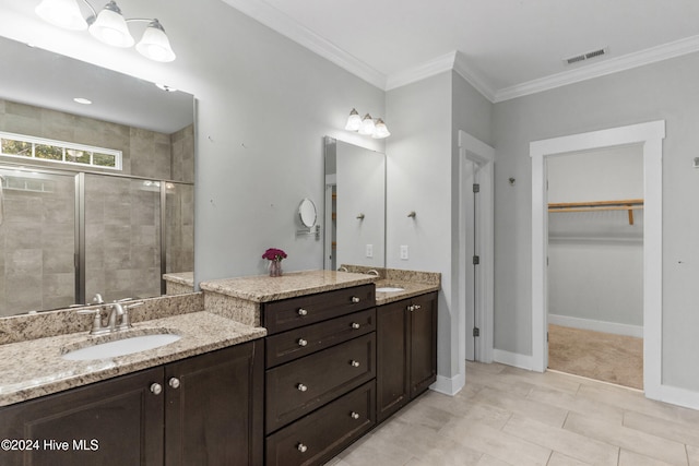 bathroom featuring vanity, a shower with door, and ornamental molding