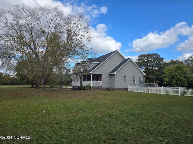 view of home's exterior with covered porch and a yard