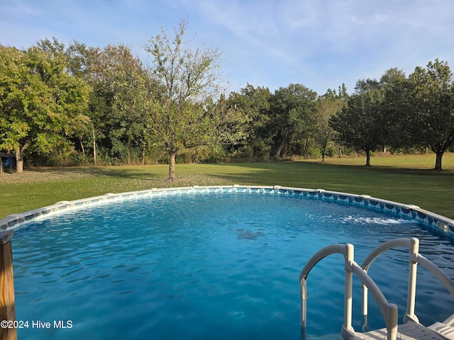 view of swimming pool with a lawn