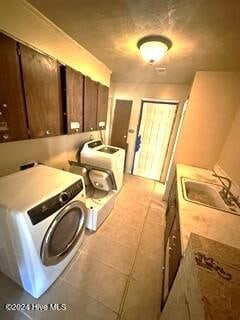 kitchen featuring sink, washing machine and dryer, and light tile patterned floors