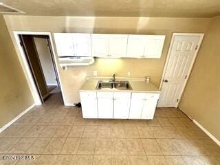 kitchen featuring white cabinets, sink, and exhaust hood