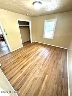 unfurnished bedroom featuring a closet and light wood-type flooring