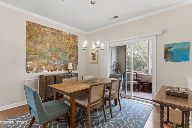 dining area featuring hardwood / wood-style floors, an inviting chandelier, and ornamental molding