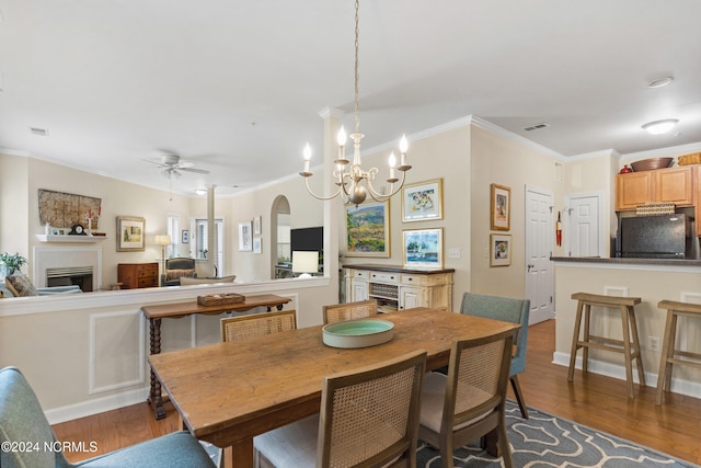 dining area featuring crown molding, dark wood-type flooring, and ceiling fan