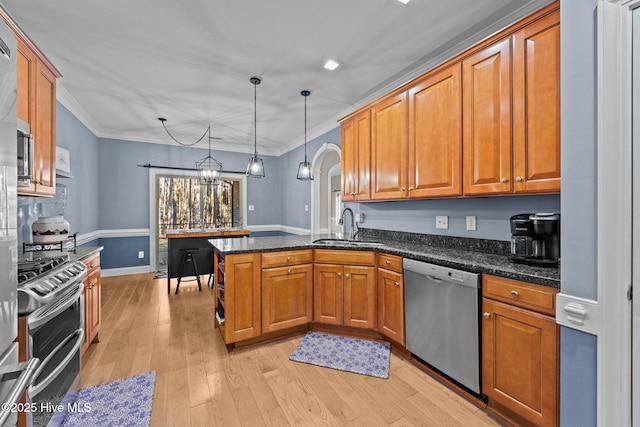 kitchen with sink, hanging light fixtures, light hardwood / wood-style flooring, kitchen peninsula, and stainless steel appliances