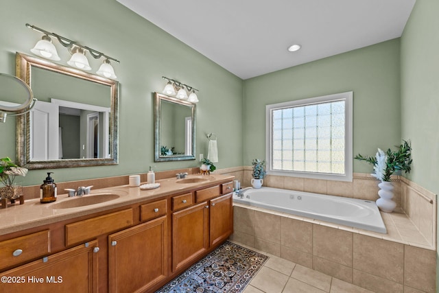 bathroom featuring tile patterned flooring, vanity, and tiled bath