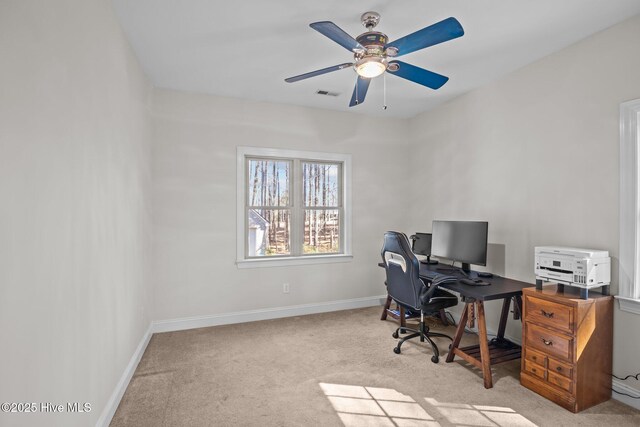 bedroom with a closet, light colored carpet, visible vents, ceiling fan, and baseboards