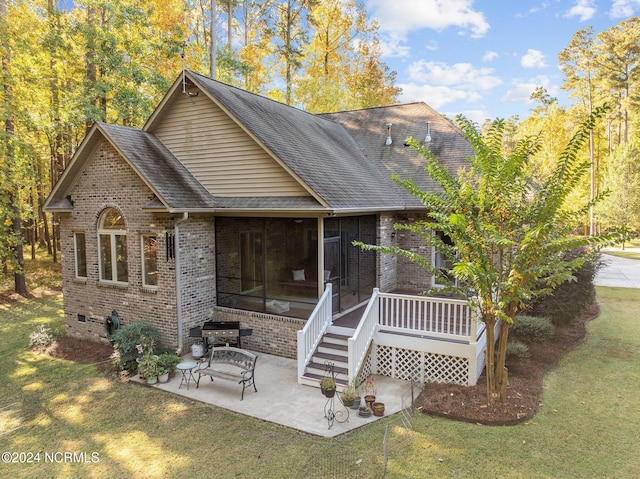 back of house with a sunroom, a patio area, and a yard