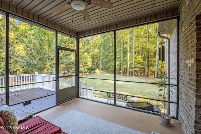 unfurnished sunroom featuring ceiling fan