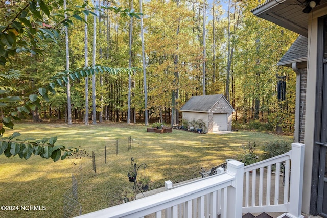 view of yard featuring a garage, an outbuilding, and a wooden deck