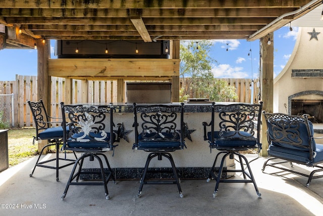 view of patio with an outdoor bar and exterior fireplace