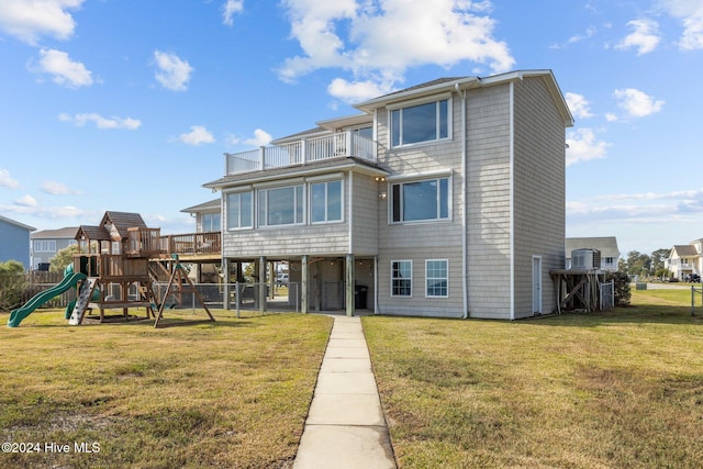 exterior space with a balcony, a playground, and a front yard